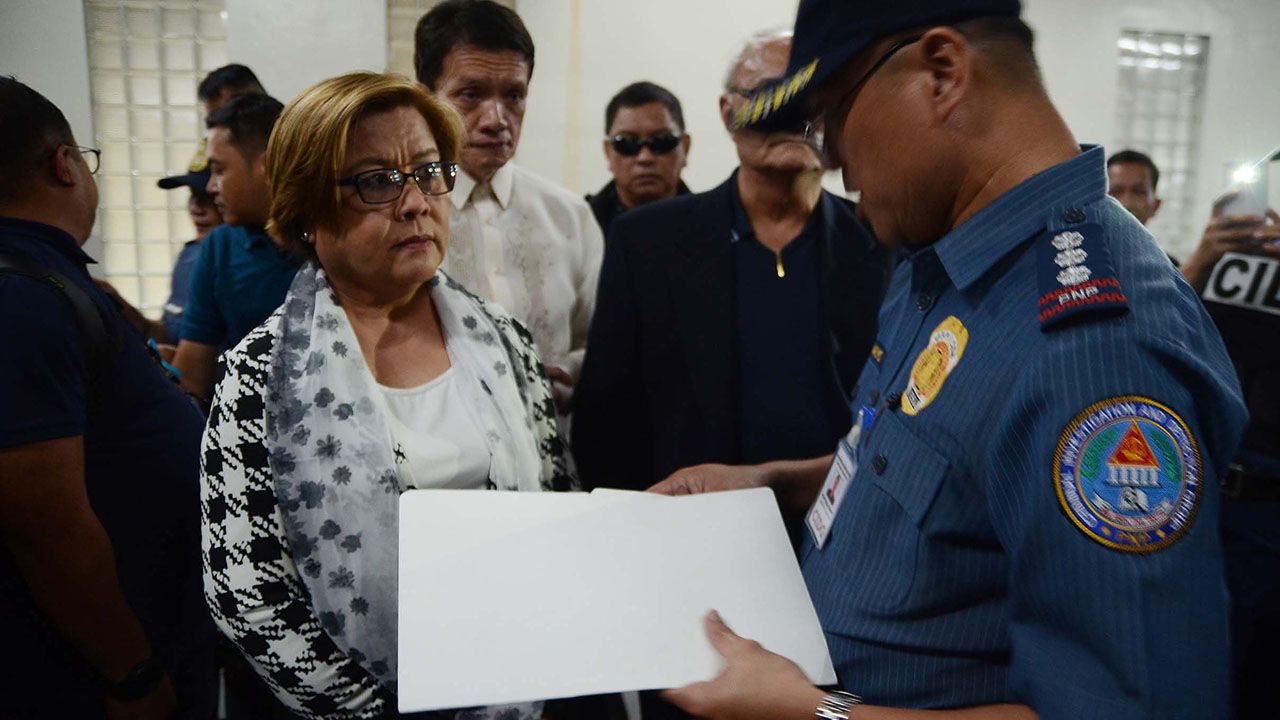 Image: wiki commons - Senator Leila De Lima listens to a PNP-CIDG officer who served the warrant for her arrest at the Senate grounds in Pasay City.  